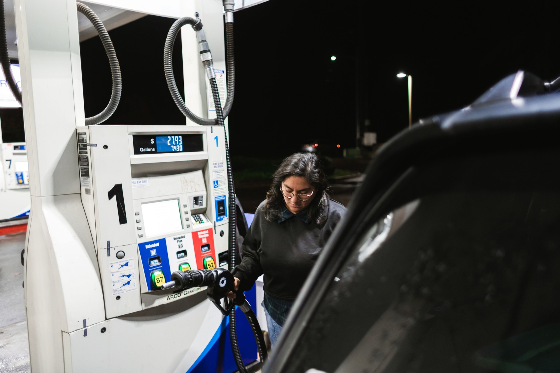 Hispanic Woman Refueling Car at a Gas Station